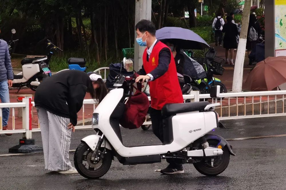 委机关干部在文明劝导中,帮骑车摔倒的群众扶电动车 委机关干部在文明劝导中,帮骑车摔倒的群众扶电动车